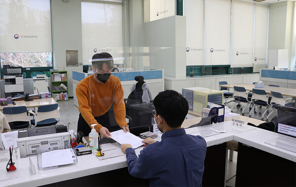 진휘현 주무관이 경기동부보훈치청을 찾은 민원인에게 처리 완료된 서류를 넘겨주고 있다.